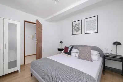 a white bedroom with a bed and a desk at 4 bedroom apartment with a balcony - Prochowa 1 in Kraków