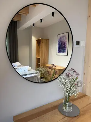 a mirror in a room with a table with flowers at Szlak By Trafił in Poręba Wielka