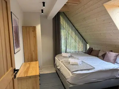 a bed in a room with a large window at Szlak By Trafił in Poręba Wielka