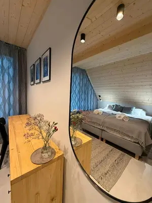 a mirror reflecting a bedroom with a bed in a room at Szlak By Trafił in Poręba Wielka