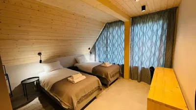 a room with two beds in a wooden room at Szlak By Trafił in Poręba Wielka