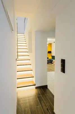 a staircase in a house with white walls and wooden floors at Dom z ogrodem i prywatnym parkingiem w Krakowie in Kraków