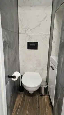 a bathroom with a white toilet in a room at Dom z ogrodem i prywatnym parkingiem w Krakowie in Kraków