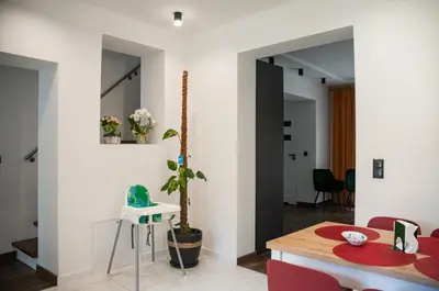 a living room with a table and red chairs at Dom z ogrodem i prywatnym parkingiem w Krakowie in Kraków