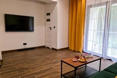 a living room with a table and a tv at Dom z ogrodem i prywatnym parkingiem w Krakowie in Kraków