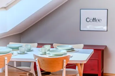 a white table with cups and saucers on it at Kraków Castle View - Spacious Apartment - by Rentujemy in Kraków