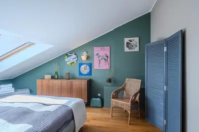 a bedroom with a bed and a chair at Kraków Castle View - Spacious Apartment - by Rentujemy in Kraków