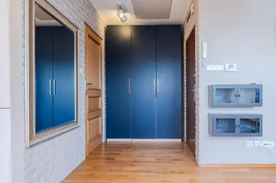 a hallway with blue cabinets and a brick wall at Kraków Castle View - Spacious Apartment - by Rentujemy in Kraków