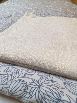 a close up of a white blanket on a bed at Art Inn Space in Kraków