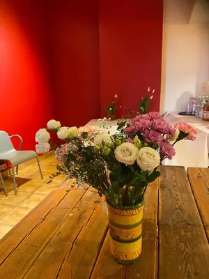 a vase of flowers sitting on a wooden table at Art Inn Space in Kraków