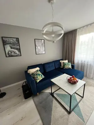 a living room with a blue couch and a table at Apartament Eva in Kraków