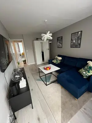 a living room with a blue couch and a table at Apartament Eva in Kraków