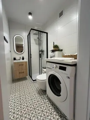 a bathroom with a washing machine and a toilet at Apartament Eva in Kraków