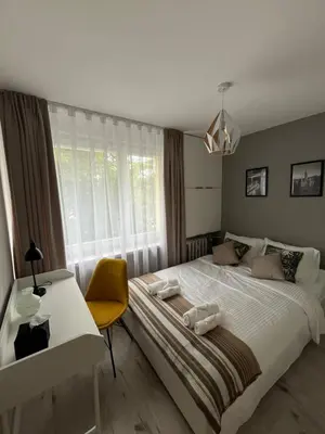 a bedroom with a bed and a desk and a window at Apartament Eva in Kraków