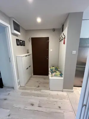 a hallway with a door and a bed in a room at Apartament Eva in Kraków