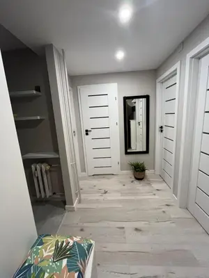 a hallway with two white doors and a mirror at Apartament Eva in Kraków