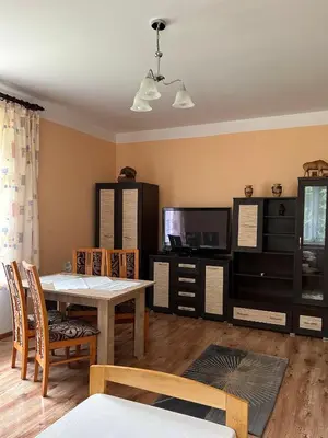 a living room with a dining table and a tv at Leśniewscy - Pokoje Gościnne in Ojców