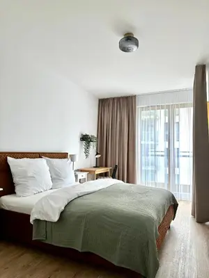 a bedroom with a large bed and a window at Sunrise Apartment in Kraków