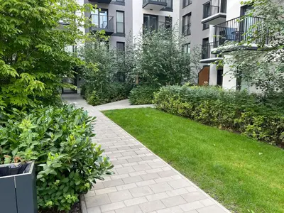 a walkway in a courtyard with grass and buildings at Sunrise Apartment in Kraków