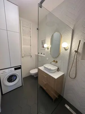 a bathroom with a sink and a washing machine at Sunrise Apartment in Kraków