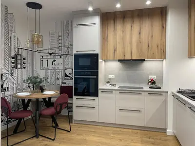 a kitchen with white cabinets and a table with red chairs at Apartament na Krowodrzy in Kraków