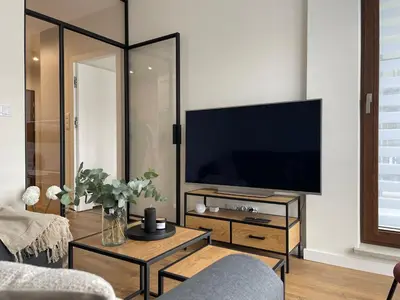a living room with a flat screen tv on a wall at Apartament na Krowodrzy in Kraków