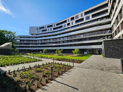 a large building with a garden in front of it at Apartament na Krowodrzy in Kraków