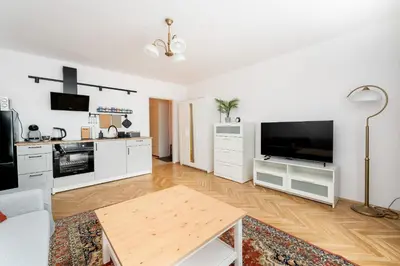 a living room with a large television and a table at Old Town Standard Studio by BookingHost in Kraków