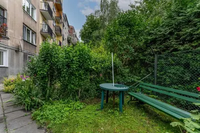 a green picnic table and a bench in a garden at Old Town Standard Studio by BookingHost in Kraków