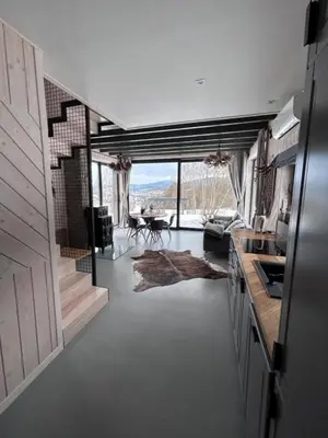 a kitchen with a view of a living room with a table at U Boku Stoku - Domki w Kasinie in Kasina Wielka