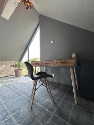 a wooden desk with a black chair in a room at U Boku Stoku - Domki w Kasinie in Kasina Wielka