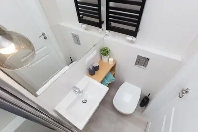 a white bathroom with a toilet and a sink at Cozy 1-bedroom apartment, Heart of Cracow in Kraków