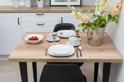 a wooden table with plates and utensils on it at Cozy 1-bedroom apartment, Heart of Cracow in Kraków
