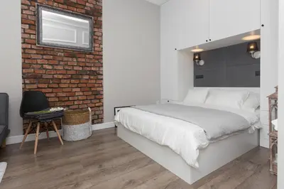 a bedroom with a bed and a brick wall at Cozy 1-bedroom apartment, Heart of Cracow in Kraków
