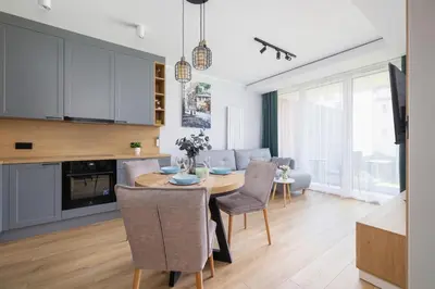 a kitchen and dining room with a table and chairs at Elegancki Apartament w Krakowie z Klimatyzacją i Dostępem do Siłowni by Noclegi Renters in Kraków