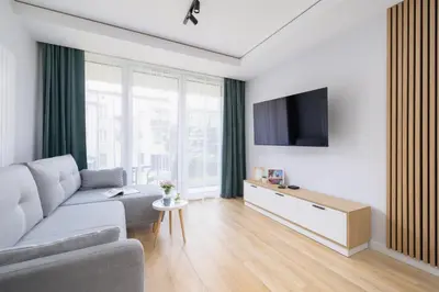 a living room with a couch and a tv at Elegancki Apartament w Krakowie z Klimatyzacją i Dostępem do Siłowni by Noclegi Renters in Kraków