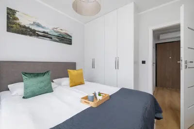 a bedroom with a bed with a wooden tray on it at Elegancki Apartament w Krakowie z Klimatyzacją i Dostępem do Siłowni by Noclegi Renters in Kraków