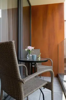 a table with two chairs and a table with flowers on it at Elegancki Apartament w Krakowie z Klimatyzacją i Dostępem do Siłowni by Noclegi Renters in Kraków