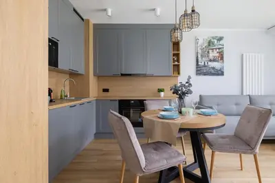 a kitchen and dining room with a table and chairs at Elegancki Apartament w Krakowie z Klimatyzacją i Dostępem do Siłowni by Noclegi Renters in Kraków