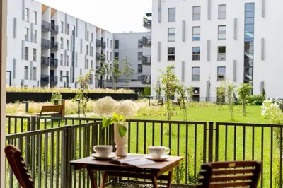 a table and chairs on a balcony with buildings at Lema Apartment near Tauron Arena in Kraków