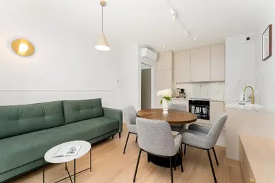 a living room with a green couch and a table at Lema Apartment near Tauron Arena in Kraków