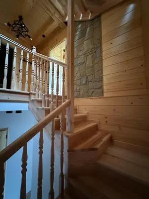 a staircase in a wooden house with a pool at Dom Na Brzegu in Limanowa