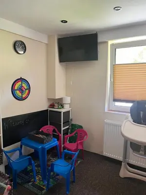 a room with four chairs and a table and a tv at Świerkowe zacisze 13km energylandia in Wożniki
