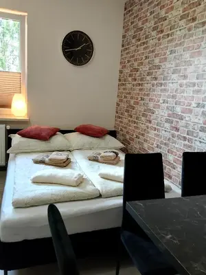 a bed in a room with a clock on the wall at Świerkowe zacisze 13km energylandia in Wożniki