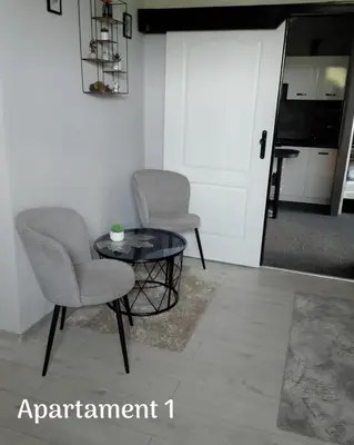 a living room with two chairs and a table at Świerkowe zacisze 13km energylandia in Wożniki