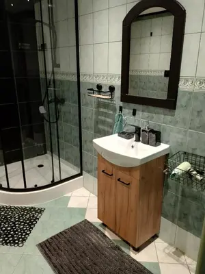 a bathroom with a sink and a shower with a mirror at Świerkowe zacisze 13km energylandia in Wożniki