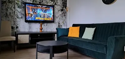 a living room with a green couch and a table at Green apartament in Oświęcim