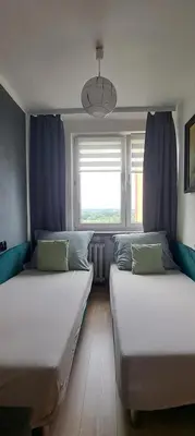 two beds in a room with a window at Green apartament in Oświęcim