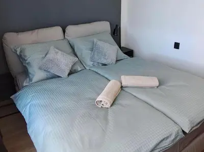 a bed with two towels and pillows on it at Green apartament in Oświęcim