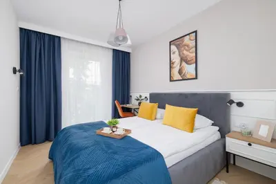 a bedroom with a large bed with a tray on it at Klimatyzowany Apartament w Centrum Krakowa z Parkingiem i Biurkiem by Renters Prestige in Kraków